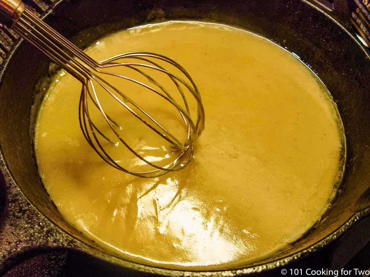 whisking gravy in cast iron skillet