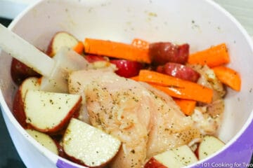 coating chicken and vegetables with oil and seasoning