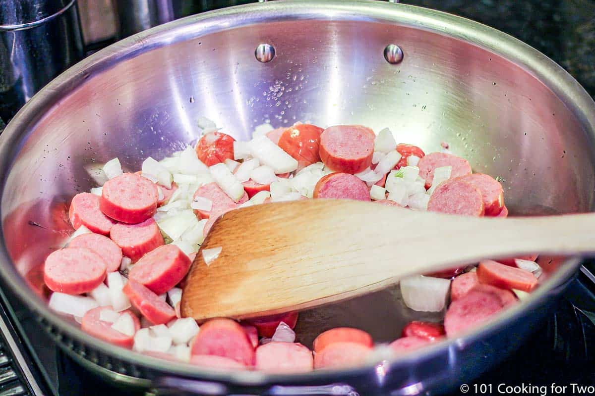 cooking sausage and onion in a large skillet