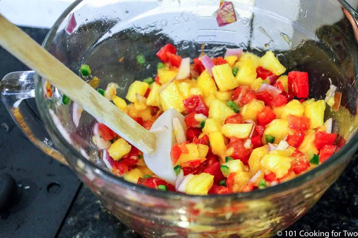 mixing salsa ingredients in a large bowl.