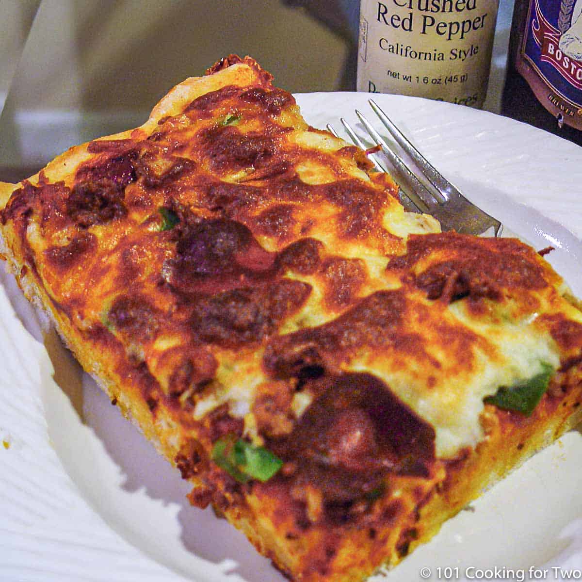 slice of homemade pizza on a white plate.