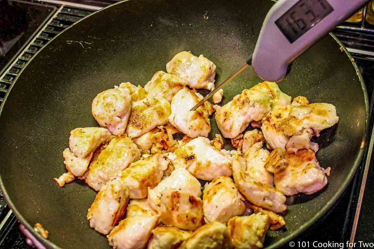Cooked chicken in black skillet.