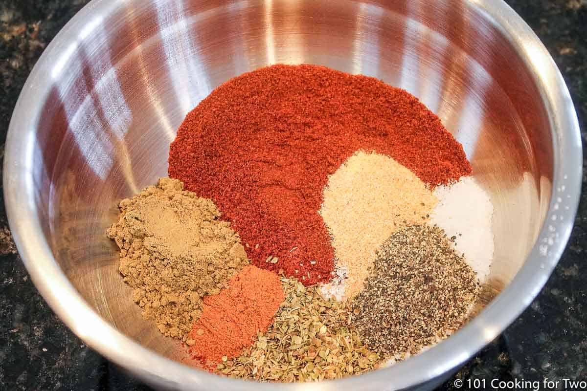 mixing spices in a metal bowl.