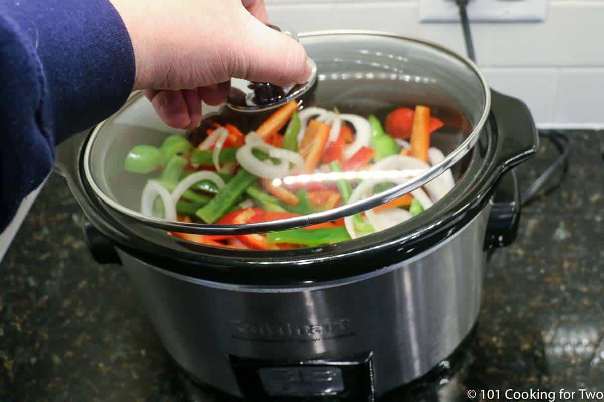 Placing lid on the crock pot.