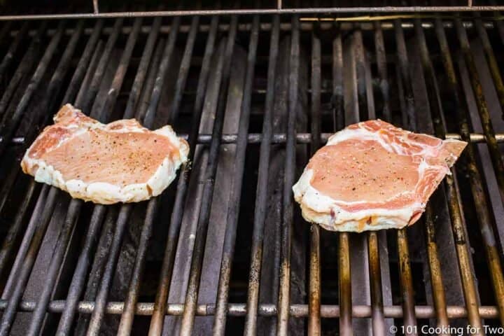 raw pork chops on grill grates