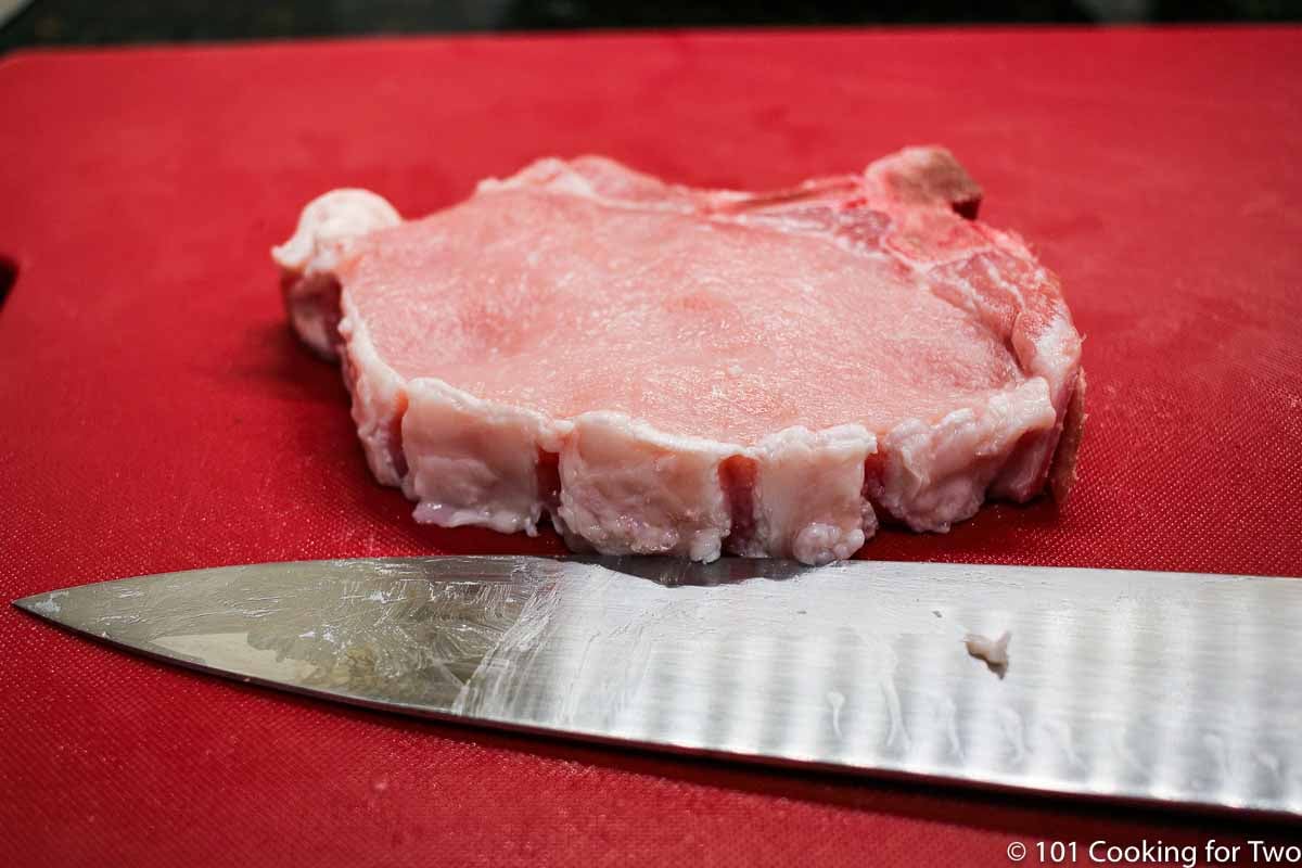 trimmed pork chop on a red mat
