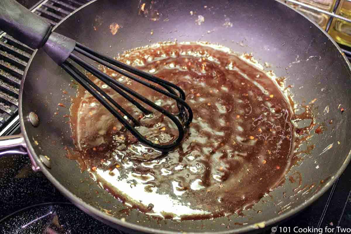 whisking sauce in pan to thicken.