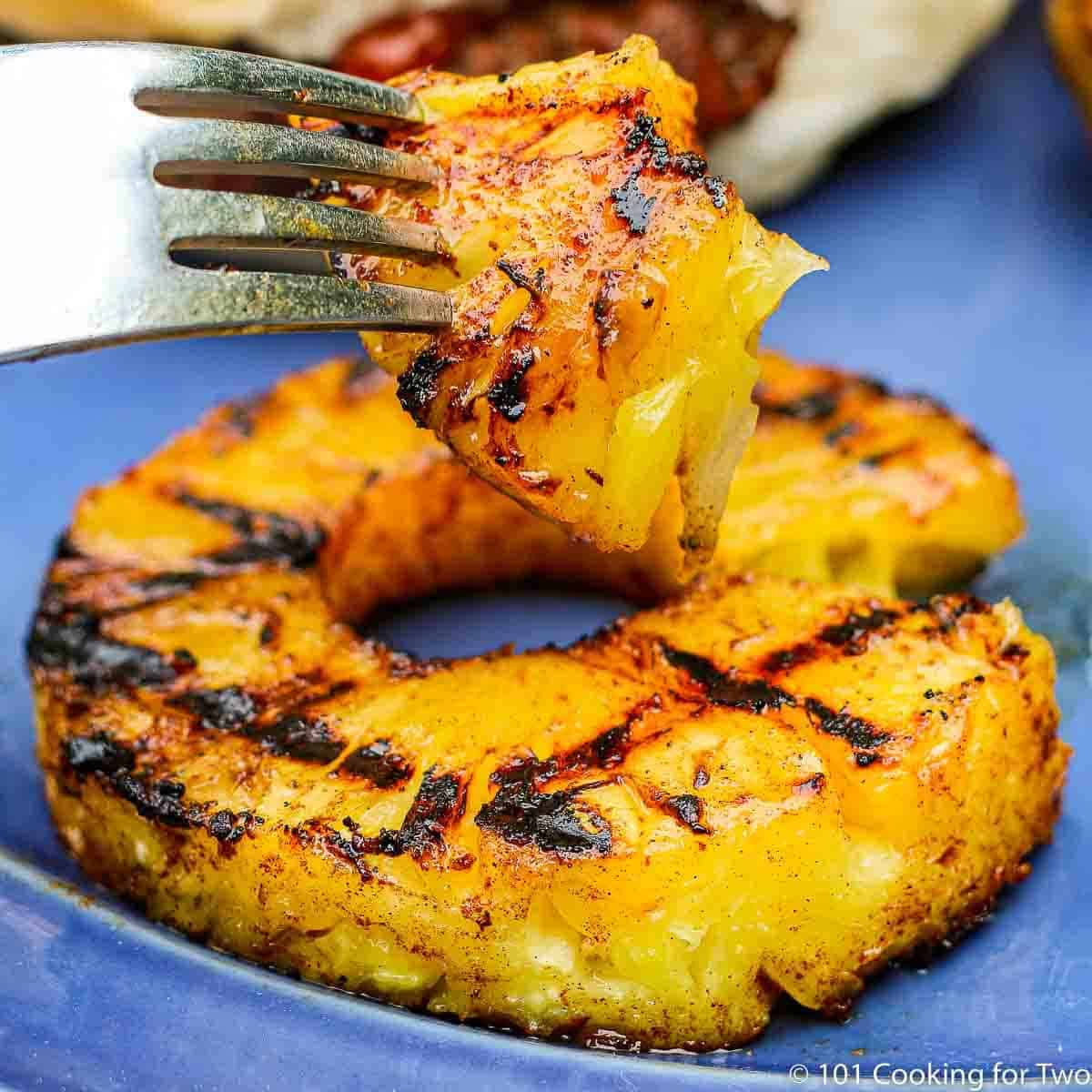 Closeup of grilled pineapple on a blue plate