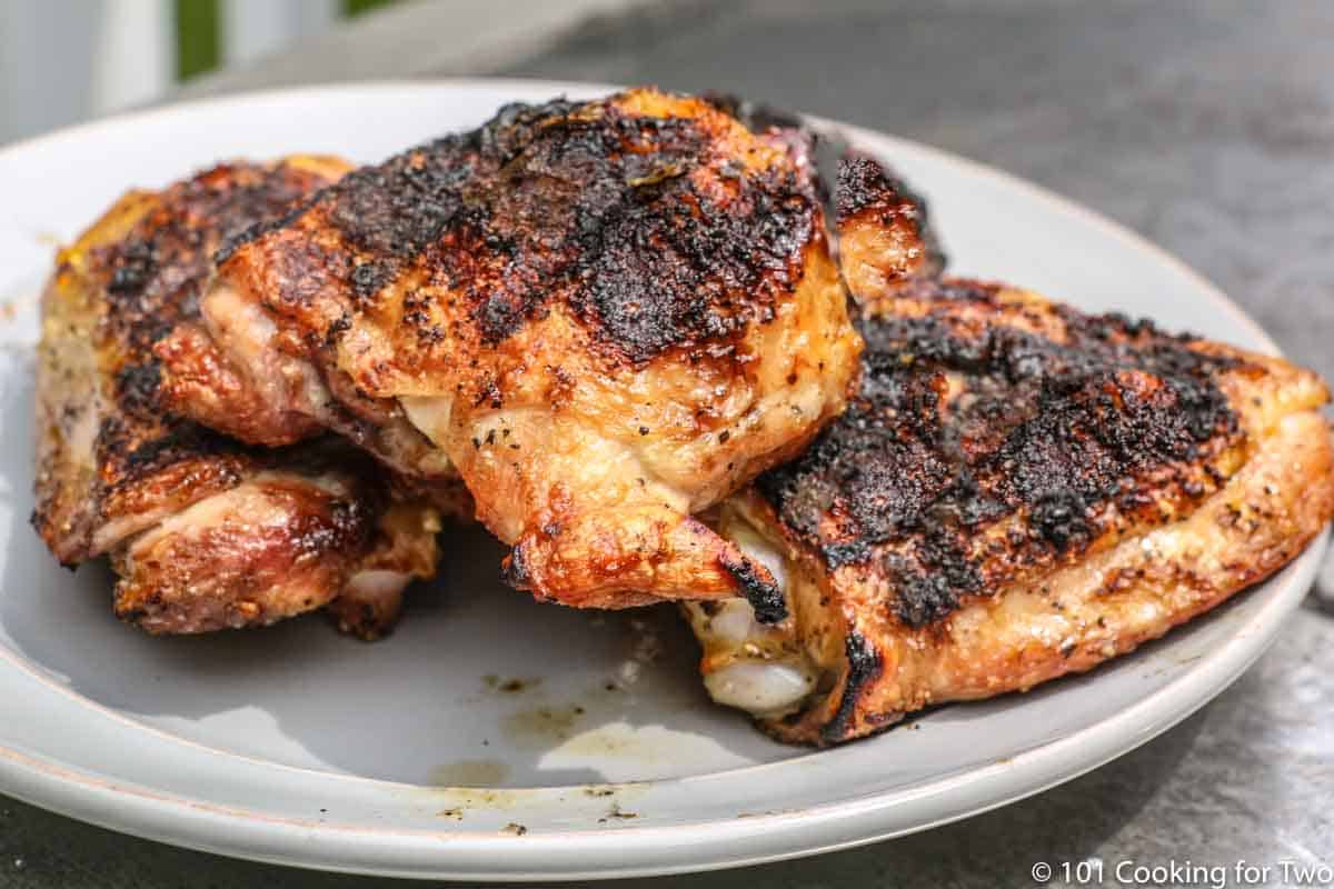 grilled chicken thighs on a gray plate.