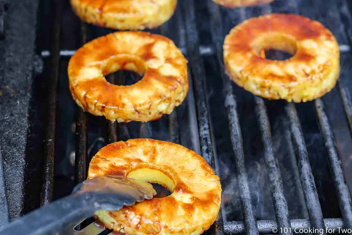 placing pineapple rings on the grill grates.