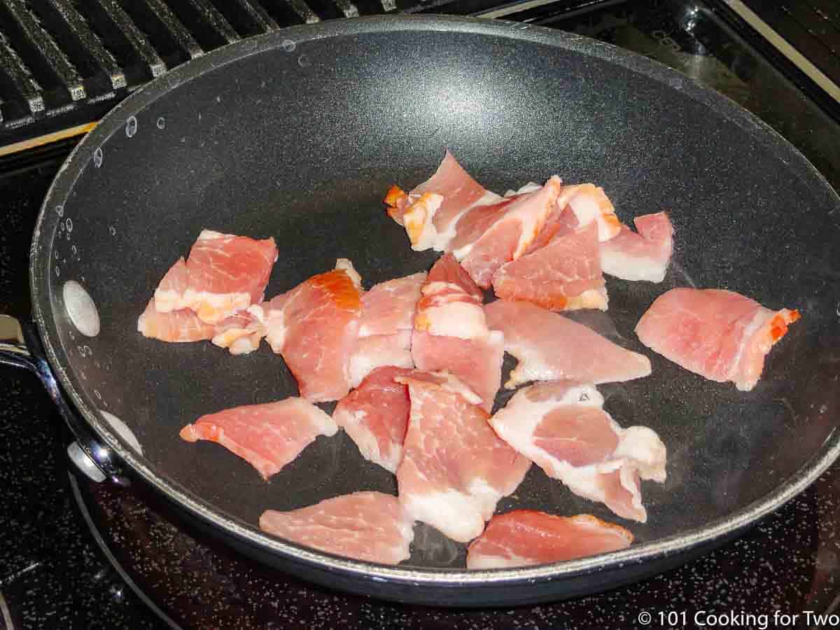 raw cutup bacon in black skillet