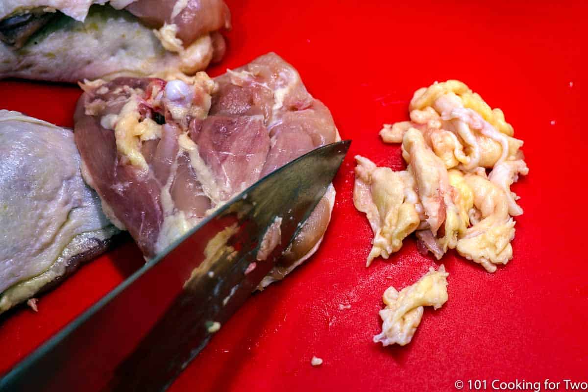 trimming fat off the chicken thigh