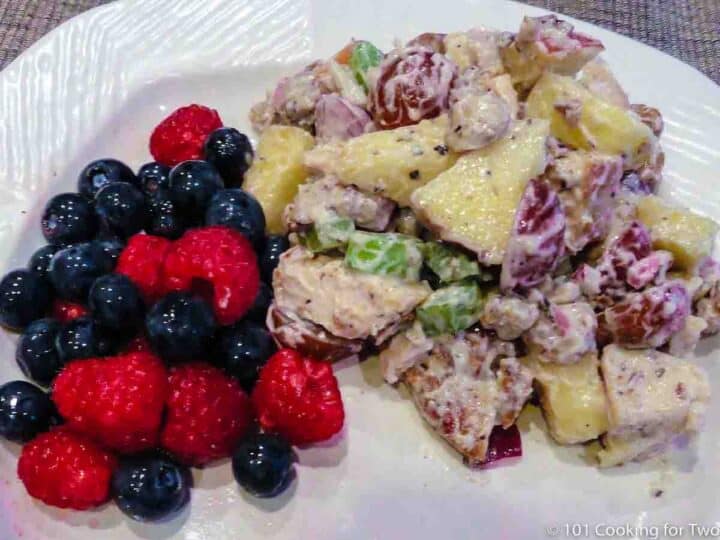 Waldorf chicken salad with fruit on white plate—Wide view