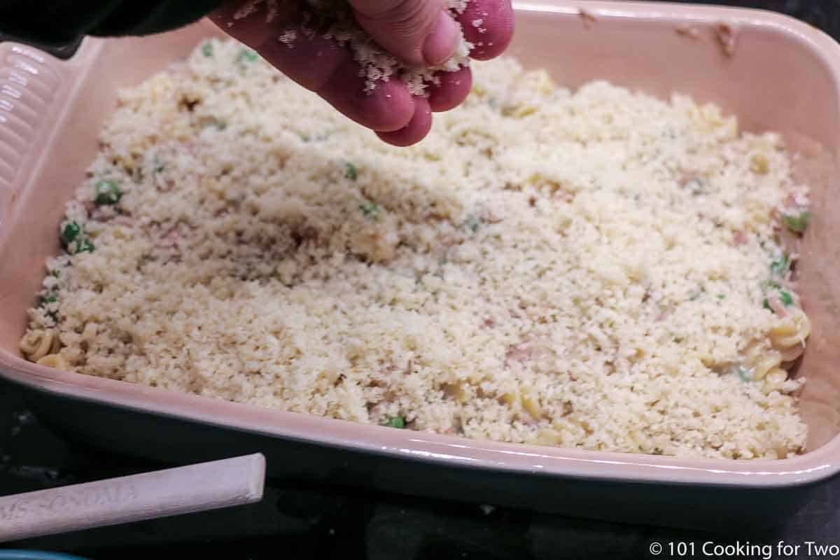 adding topping to casserole.