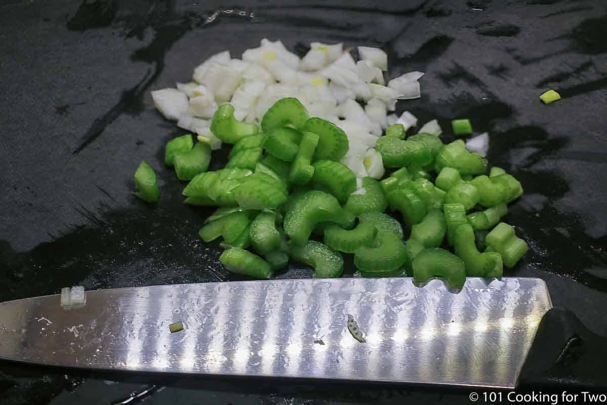 chopped celery and onion on black board