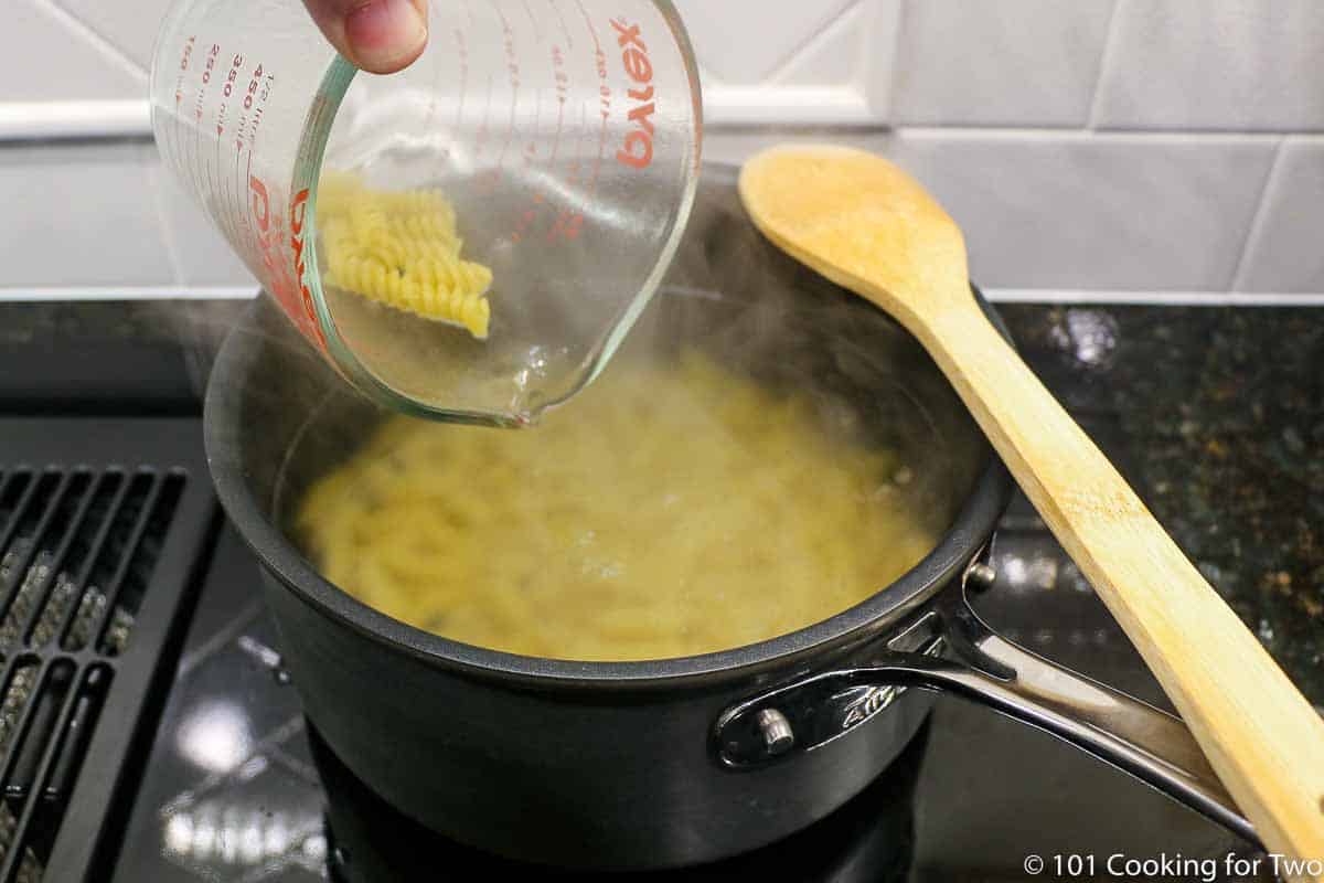 cooking pasta in black pan.