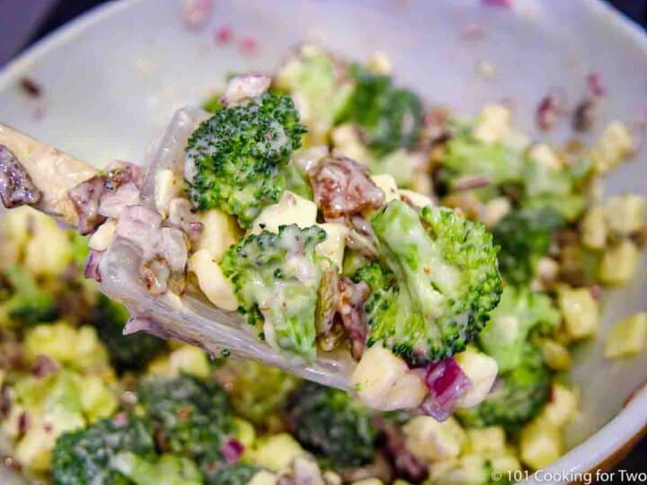 mixing broccoli salad in bowl