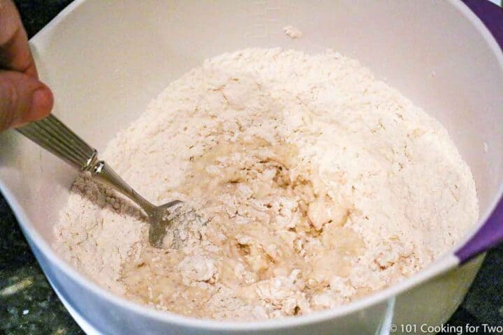 mixing dough in white bowl with a fork