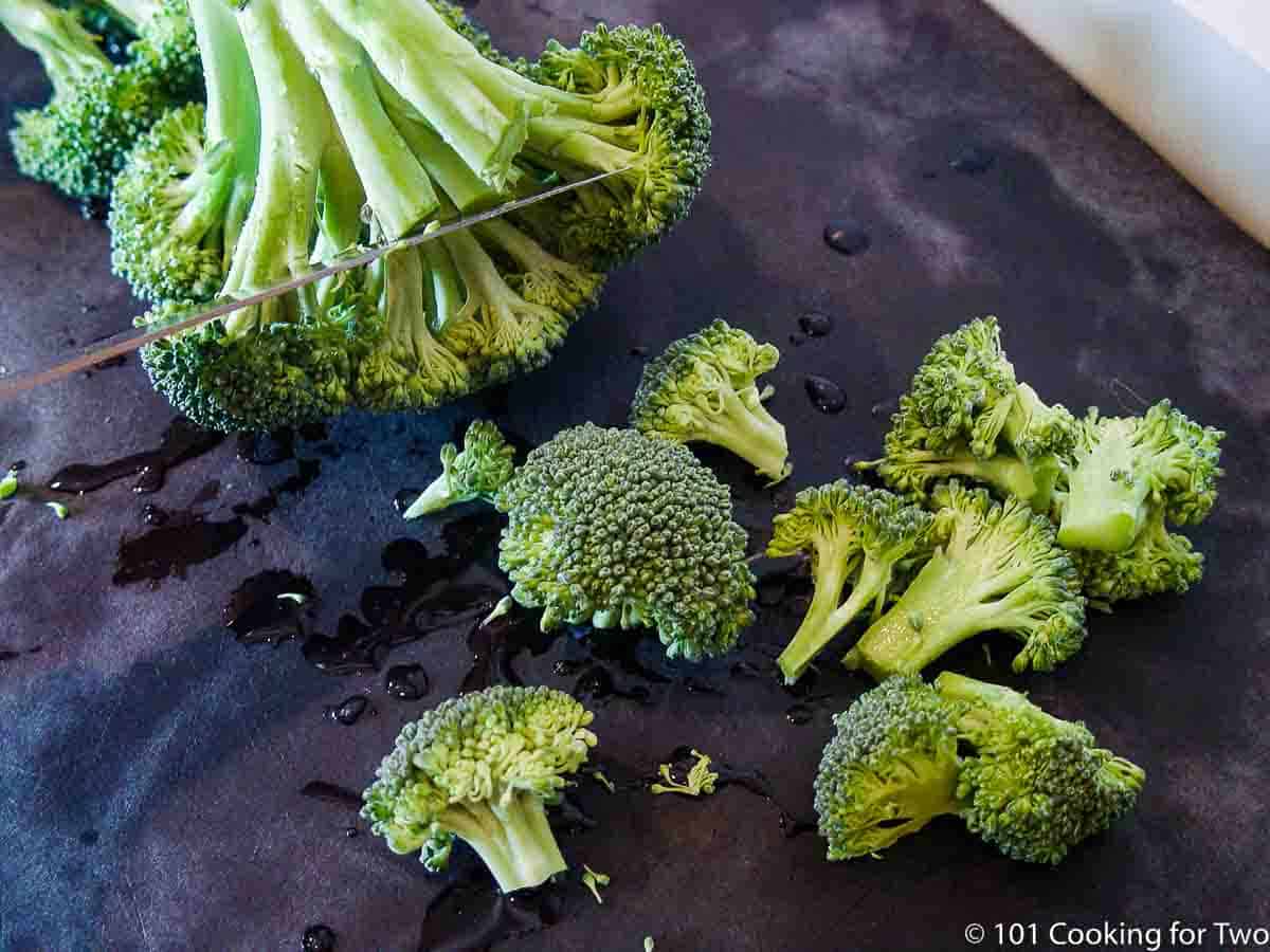 trimming broccoli on a black board.