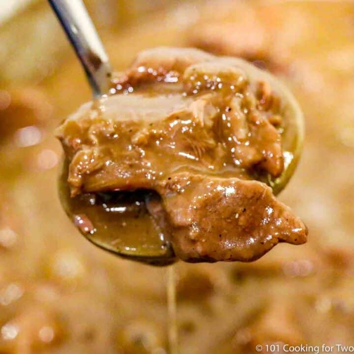 beef tips in gravy on ladle