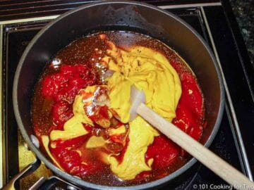 black sauce pan with ketchup with mustard and spices