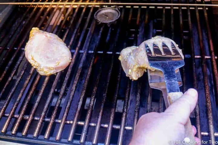 placing marinated chicken breasts on grill