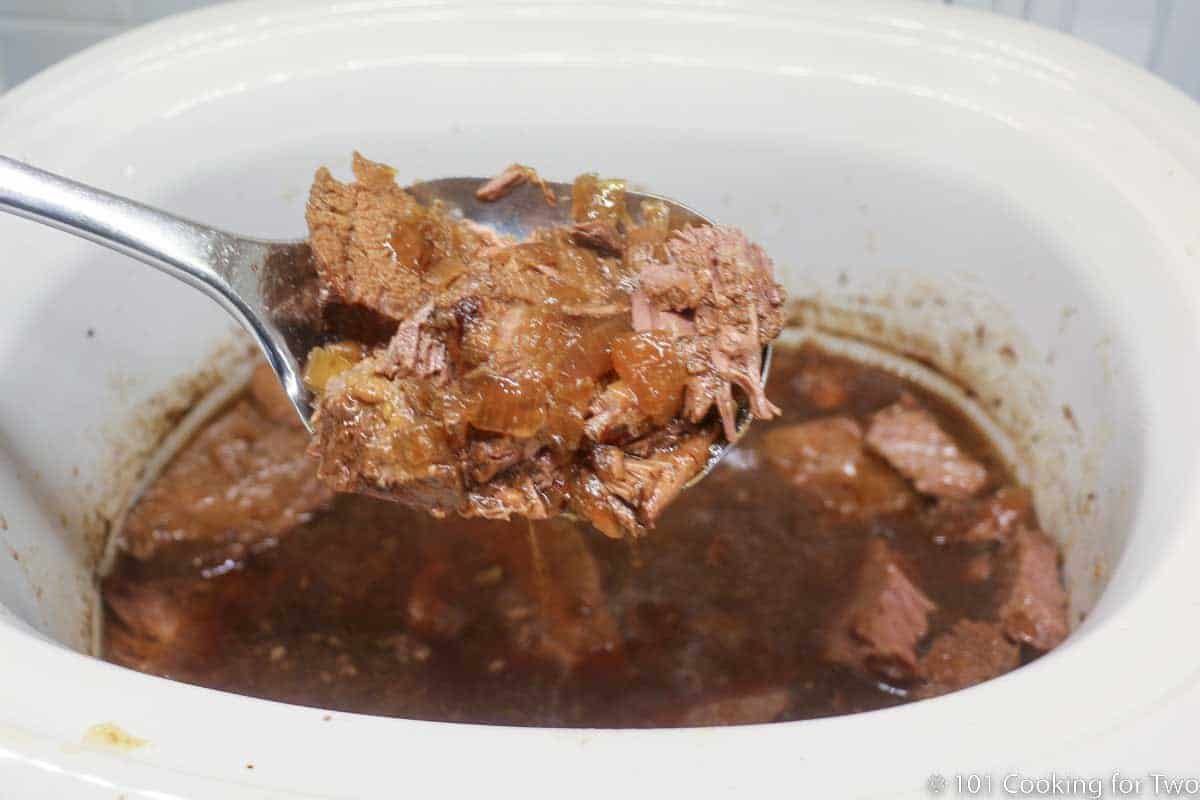French dip meat in a large serving spoon