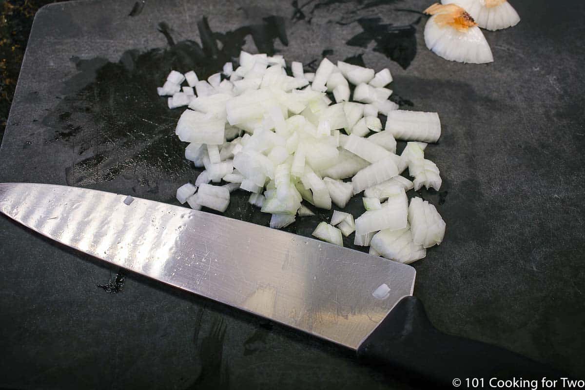 chopped onion on a black board.