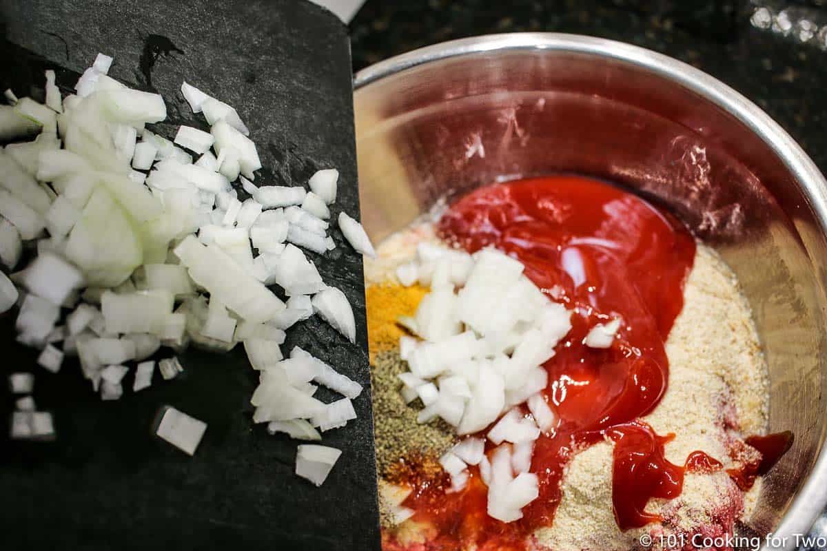 pouring chopped onion into the meat mixture.