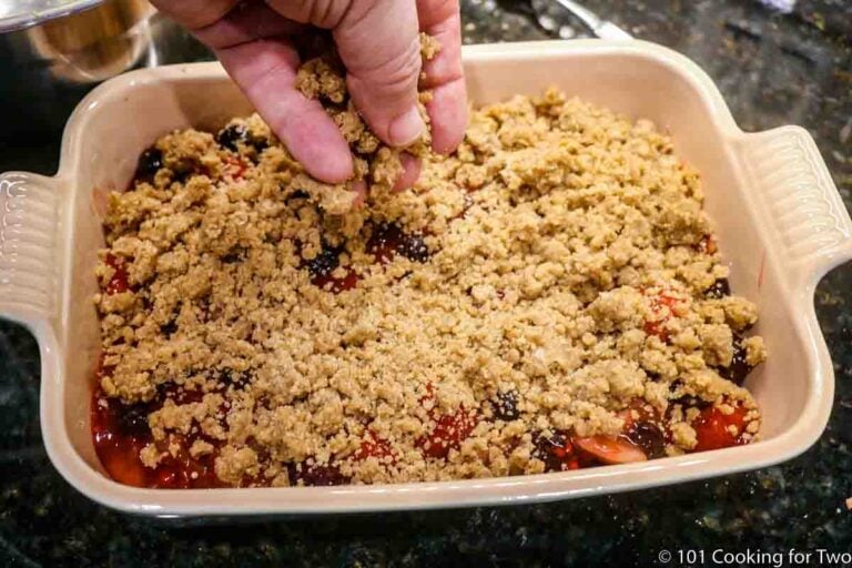 adding crumble topping to baking dish