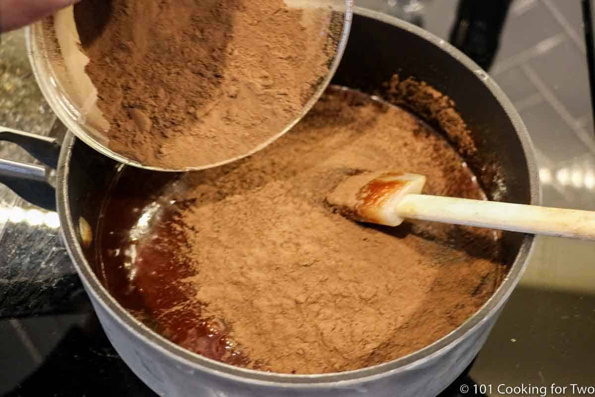 adding sifted cocoa to sauce pan.
