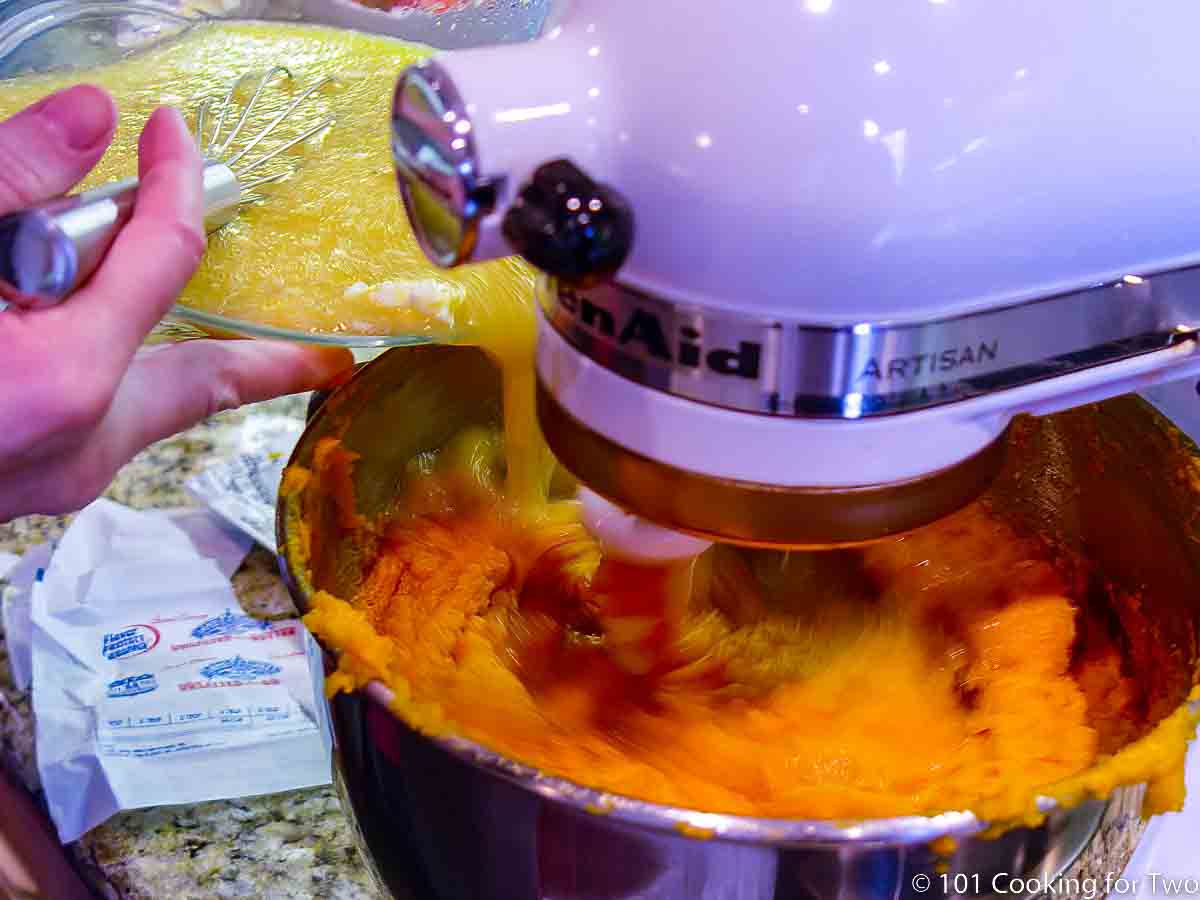 adding wet ingredients to mashed sweet potatoes on stand mixer.