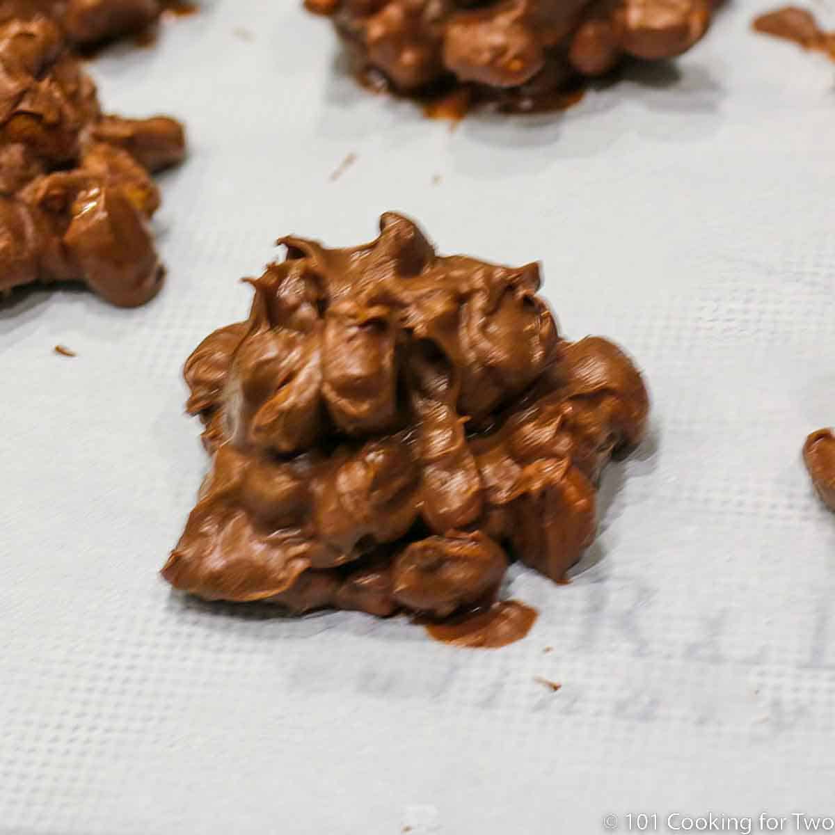 chocolate peanut cluster on parchment paper