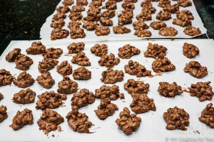 chocolate peanut clusters cooling on parchment paper