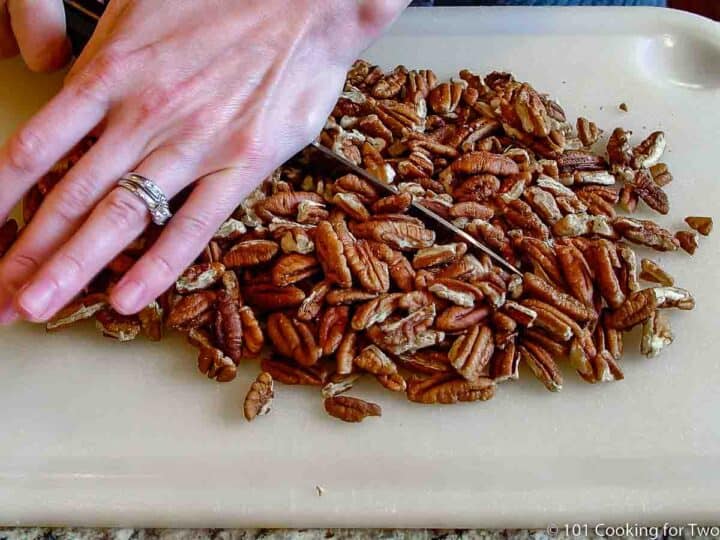 chopping pecans on a white board