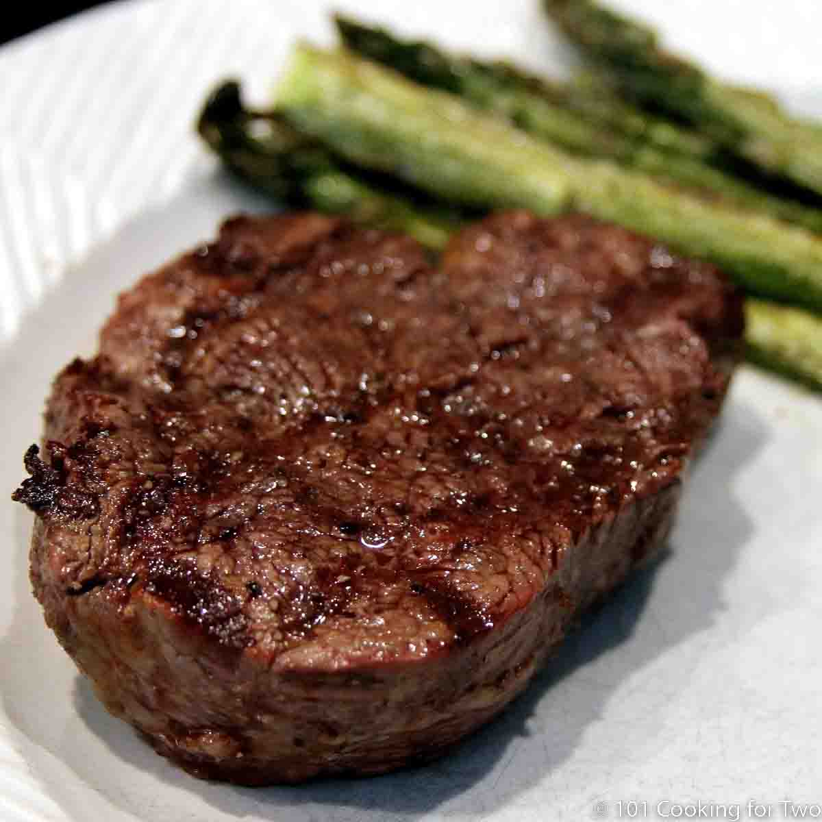 grilled filet mignon on a white plate.