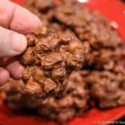 Chocolate peanut cluster being held in a hand.