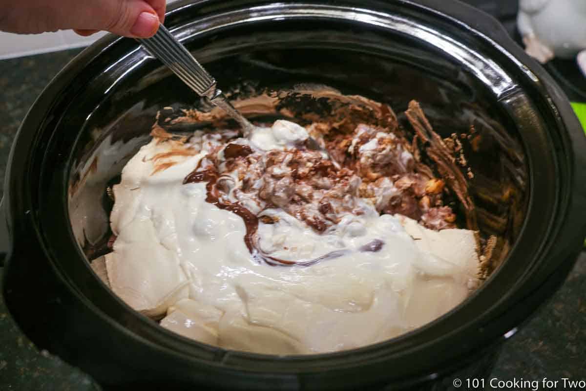 mixing melted ingredients of chocolate peanut clusters.