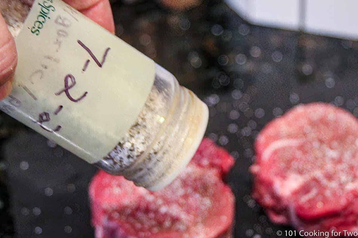 seasoning filets on a black board.