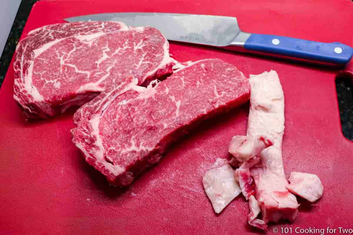 trimming fat rim from ribeye steak.