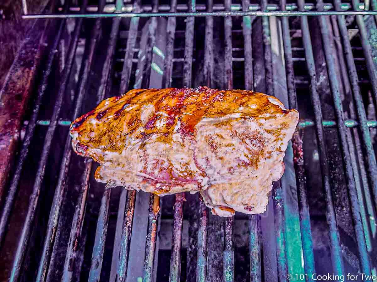 Partly cooked turkey breast on the grill.