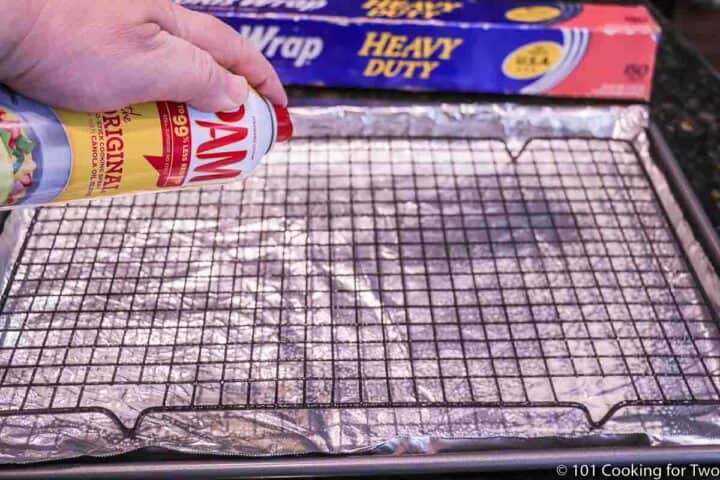 Spraying PAM on a rack on a foil covered tray