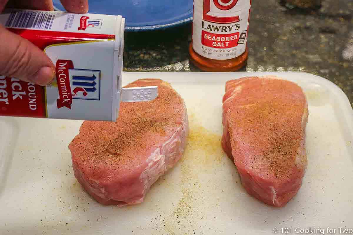 seasoning pork chops with pepper and seasoning salt.