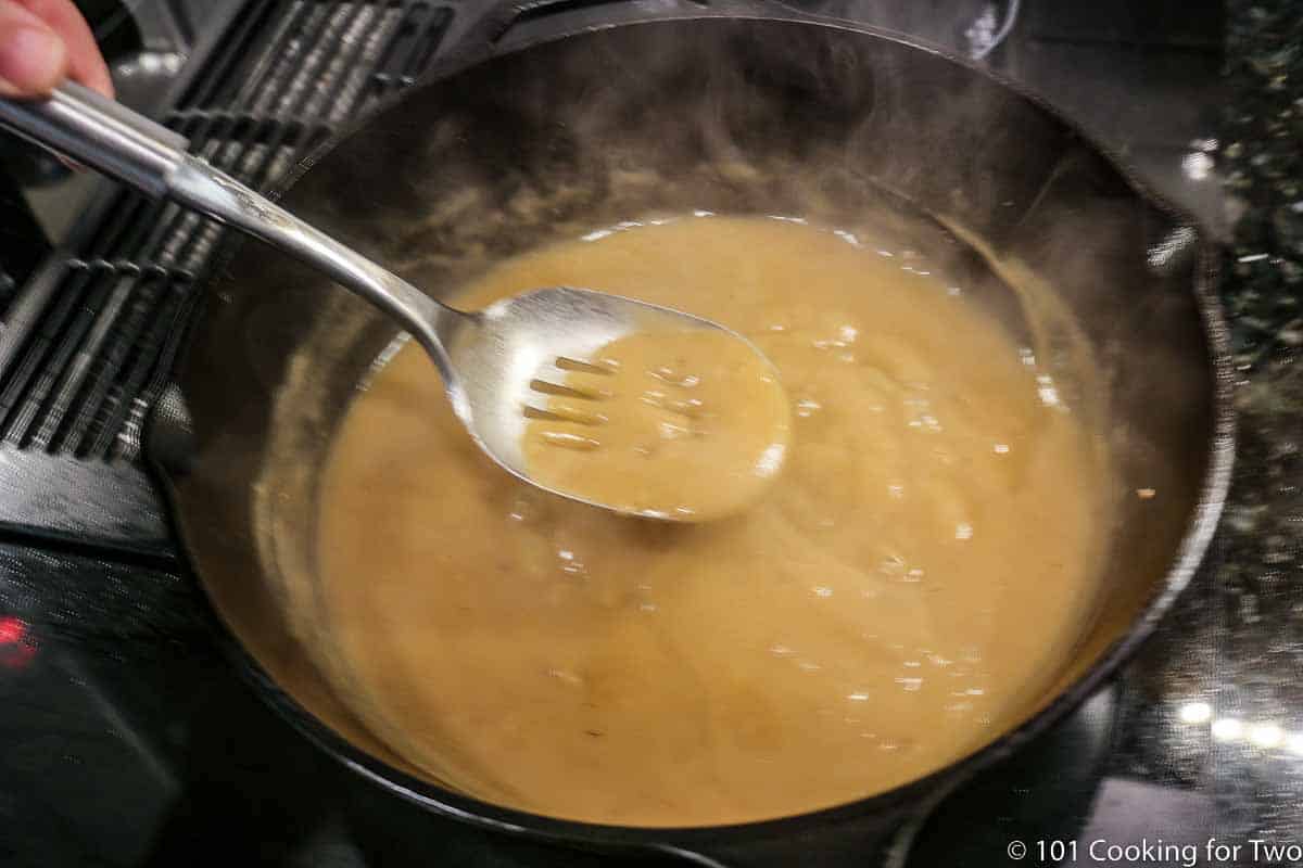 stirring brown gravy in skilling while thickening.