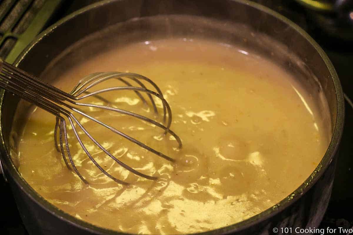 thickening gravy in pan with whisk