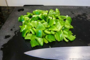 Chopped green pepper on a black board