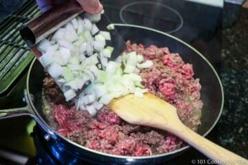 adding chopped onion to browning ground beef