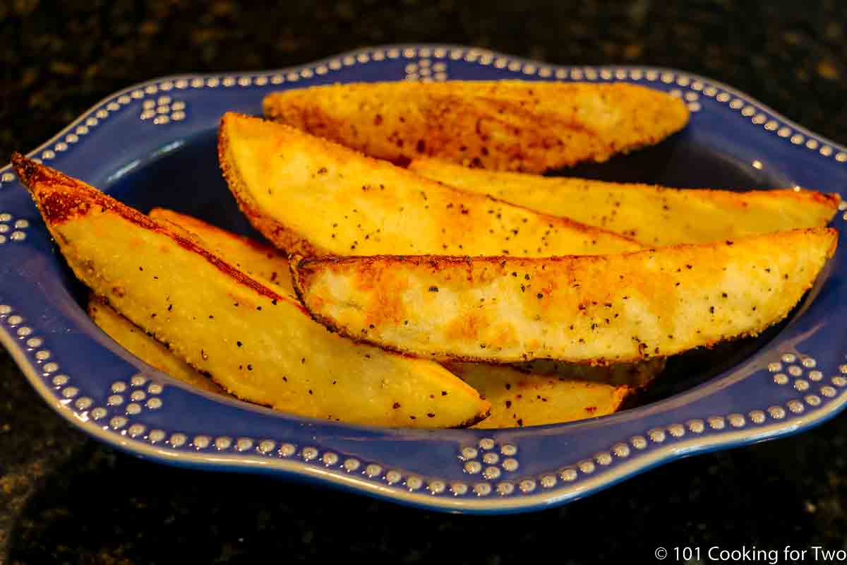 Baked potato wedges in a blue bowl