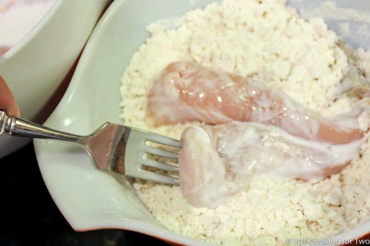 coating the chicken tenders in the flour mixture