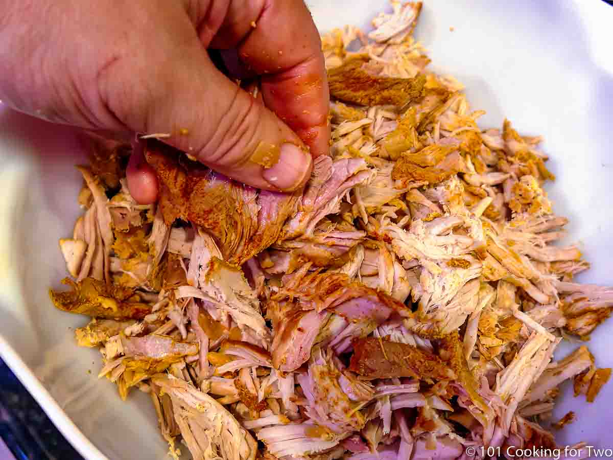 hand shredding pork loin.